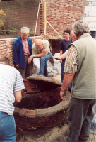 Bekijk detail van "Enkele leden van de werkgroep archeologie heemkunde en archeologische werkgroep Twente bij de opgegraven put op het terrein van pand Snijders."