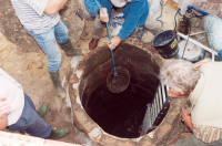 Bekijk detail van "Enkele leden van de werkgroep archeologie heemkunde en archeologische werkgroep Twente halen een oude zinken emmer op uit de put op het terrein van pand Snijders."