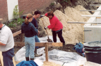 Bekijk detail van "Enkele leden van de <span class="highlight">archeologische</span> werkgroep Twente leggen de modder van de oude put op het terrein van pand Snijders voor nader onderzoek op plastic."