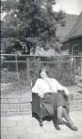 Bekijk detail van "Truus Kunne zittend in de tuin van de familie Bloemen achter hun huis aan de zijde van de Kapelstraat."