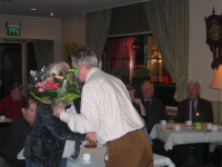 Bekijk detail van "Bestuurslid Ben van Benthem neemt afscheid van het heemkundebestuur en zijn vrouw Ria krijgt van voorzitter Jan Raatgerink een bloemetje."