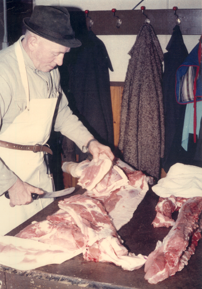 Bekijk detail van "HV01297B: Huisslachter Huisjes uit Loozen bezig met het afsnijden van een geslacht varken."