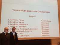Bekijk detail van "Leden van de Heemkunde Ootmarsum in het stadhuis voor de lijst met namen van oorlogsslachtoffers Gemeente Dinkelland."