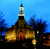 Bekijk detail van "De hoofdingang van de r.-k. kerk in sfeer <span class="highlight">verlichting</span>."