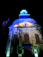 Bekijk detail van "De sfeervol verlichte voorgevel van de protestante kerk."