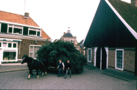 Bekijk detail van "De paaswagen met hoog opgeladen paashout rijdt via de Keerweer en Kerkplein richting Poaskaamp (<span class="highlight">paaskamp</span>)."