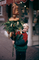 Bekijk detail van "Een kind staat met zijn palmpasen in de hand te wachten op het begin van de palmpasenoptocht."